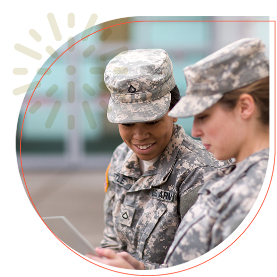 Two females who are active military looking at an ipad