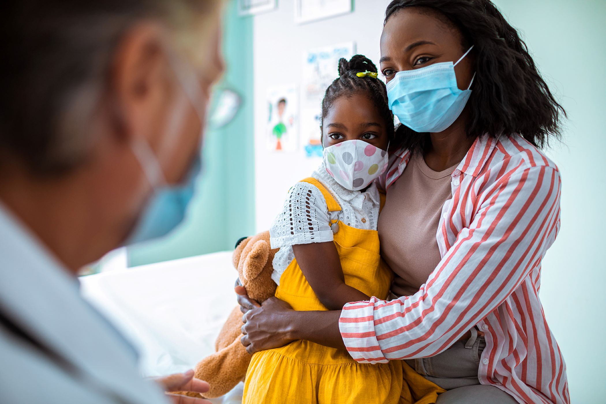 Masked mother and daughter at doctor's appointment