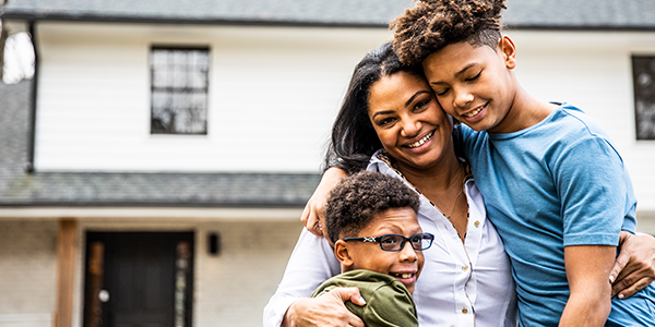 Lady hugging sons outside of home