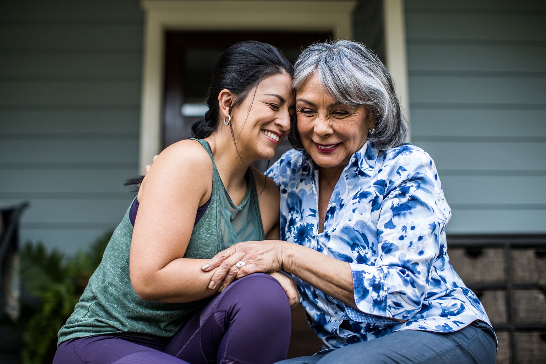 Mother and daughter hugging on porch