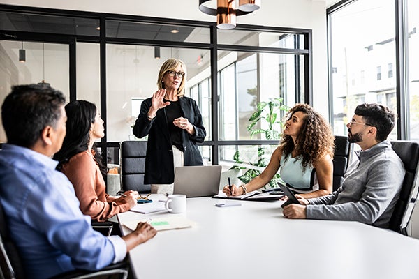 Female leader talking with group in a meeting. 