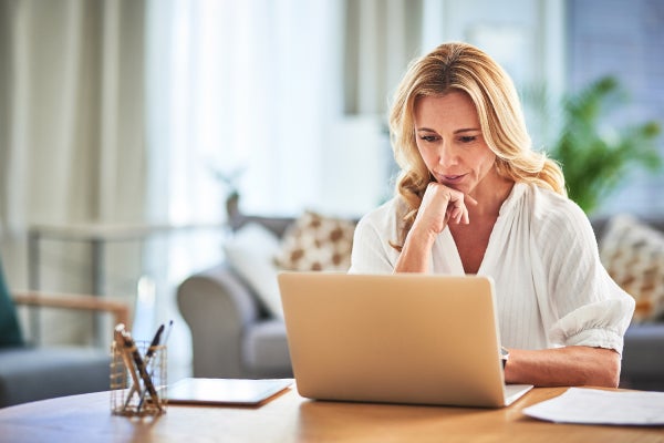Female looking at computer at home desk